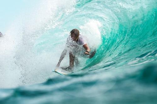 homem surfando onda